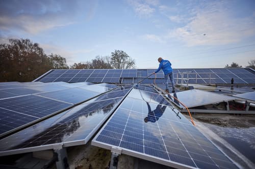 Sparidaens aan het werk bij het reinigen van zonnepanelen op een dak